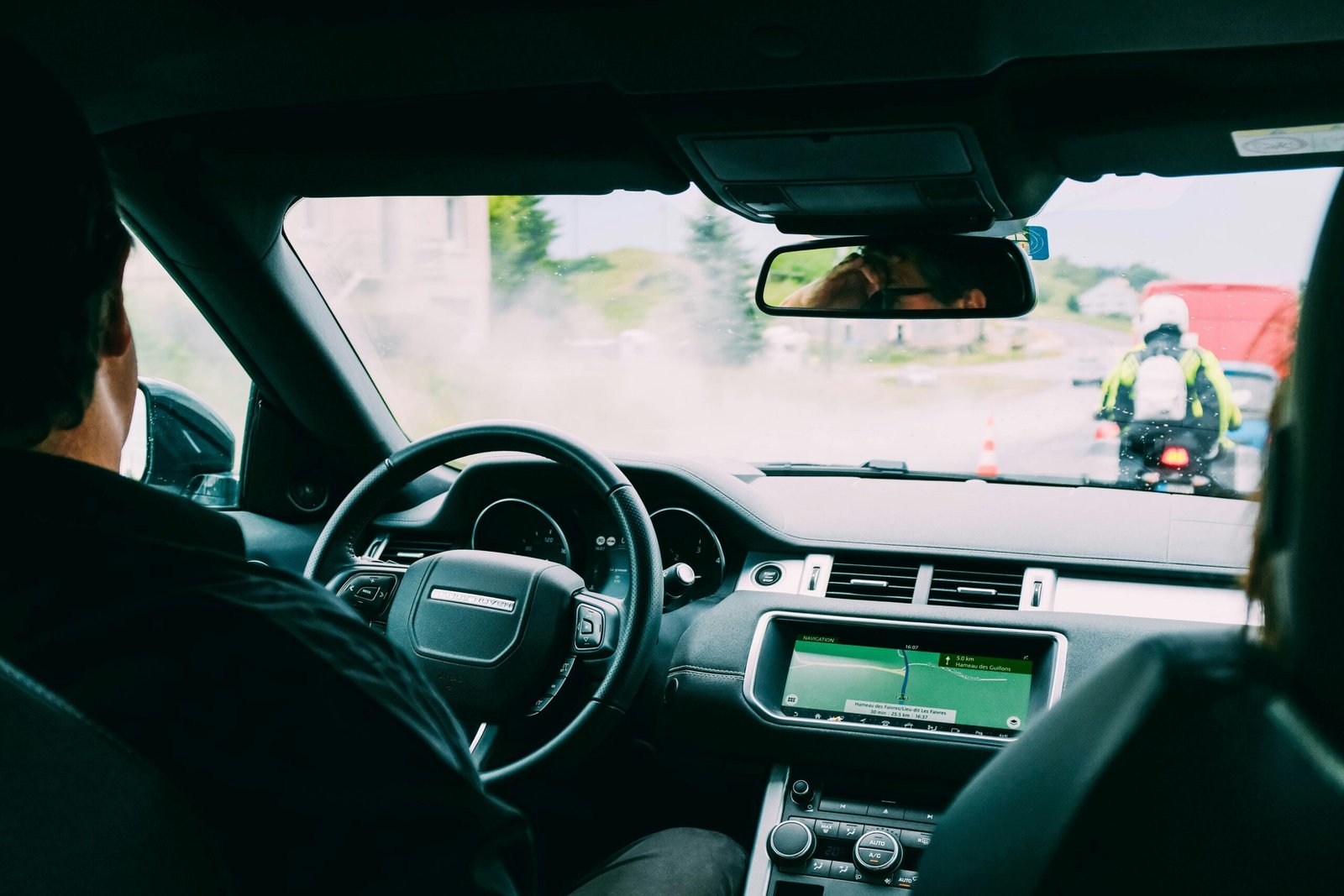 gun in car with passengers view from the back seat showing occupants and the front interior of a vehicle